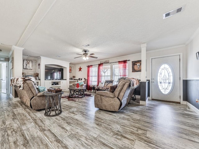 living room featuring hardwood / wood-style floors, ceiling fan, a textured ceiling, and a wealth of natural light