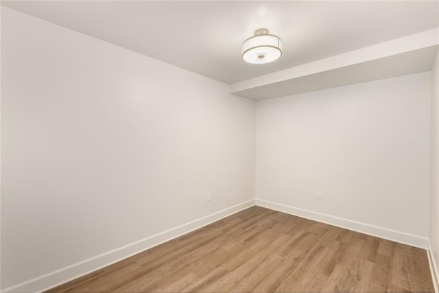 empty room with baseboards and light wood finished floors