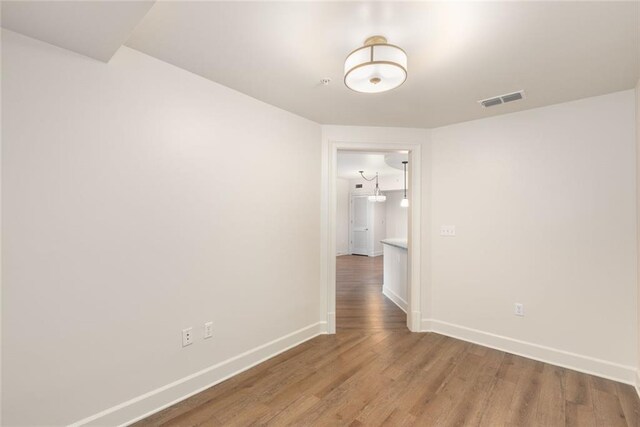 spare room featuring baseboards, visible vents, and light wood-style flooring