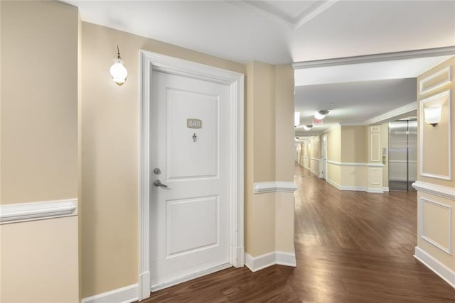 foyer with ornamental molding, wood finished floors, elevator, and baseboards
