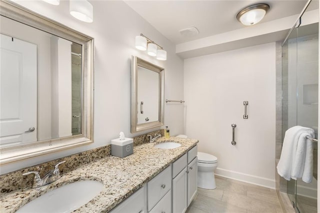 bathroom featuring double vanity, toilet, a stall shower, and a sink