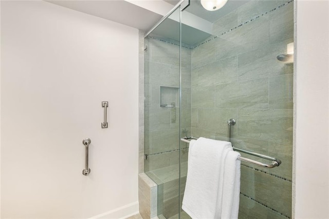 bathroom with baseboards and a stall shower