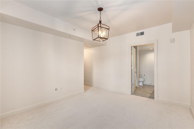 unfurnished room featuring a notable chandelier, visible vents, light colored carpet, and baseboards