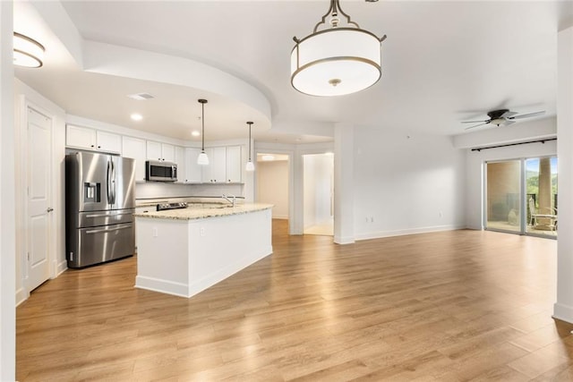 kitchen with light wood-style flooring, ceiling fan, and stainless steel appliances