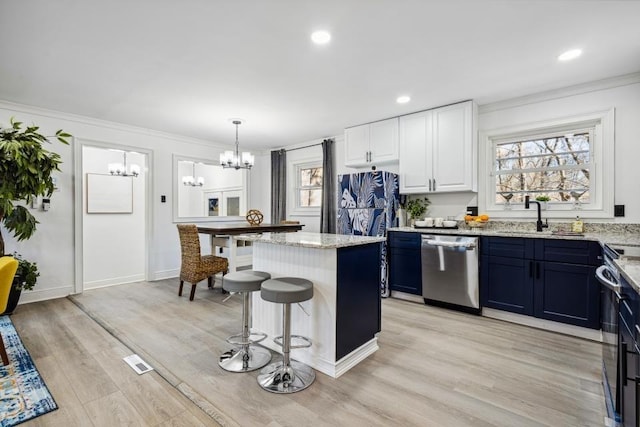 kitchen featuring pendant lighting, white cabinets, dishwasher, a kitchen island, and light hardwood / wood-style floors