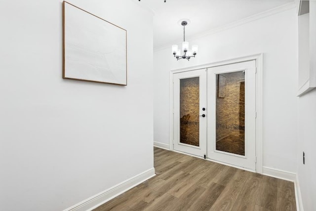 doorway featuring ornamental molding, hardwood / wood-style floors, and a notable chandelier