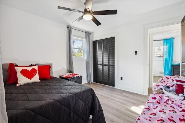 bedroom featuring ceiling fan, light hardwood / wood-style flooring, and a closet