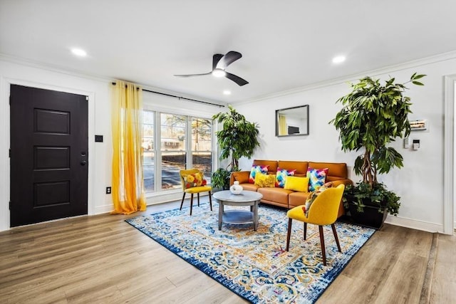 living room with ceiling fan, hardwood / wood-style floors, and ornamental molding