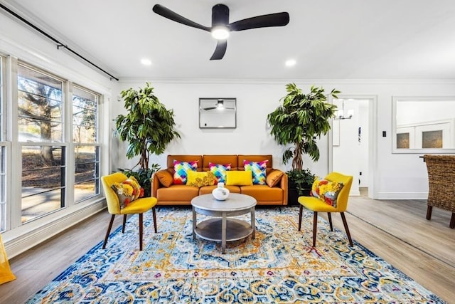 living room with ceiling fan, crown molding, and hardwood / wood-style flooring