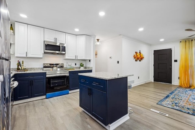 kitchen featuring white cabinets, appliances with stainless steel finishes, a center island, light wood-type flooring, and blue cabinets