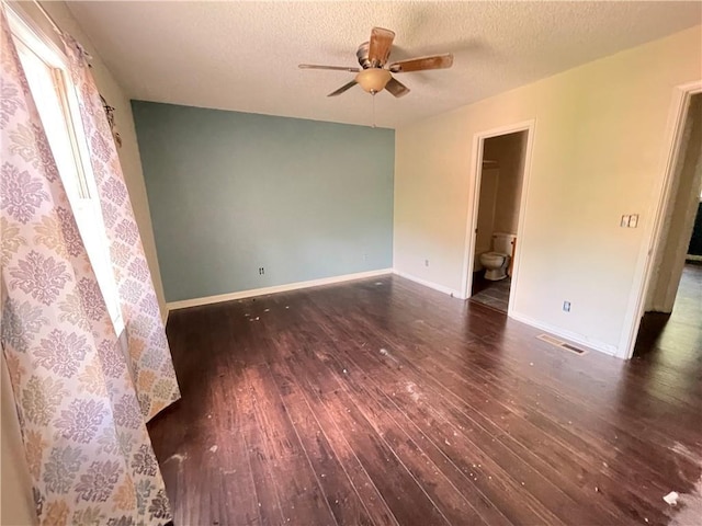 unfurnished room featuring wood-type flooring, a ceiling fan, a textured ceiling, and visible vents