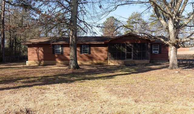 rear view of property with a sunroom and a lawn