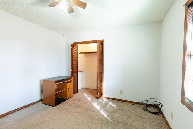 unfurnished bedroom featuring carpet floors, a textured ceiling, and ceiling fan