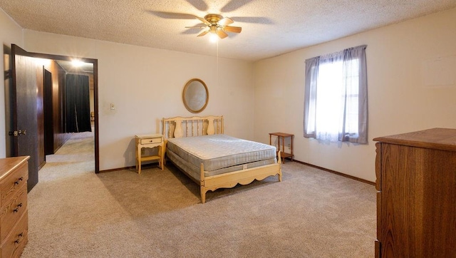 bedroom with light carpet, ceiling fan, and a textured ceiling