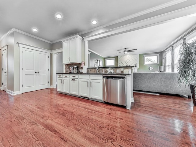 kitchen featuring dishwasher, dark countertops, wood finished floors, open floor plan, and ornamental molding