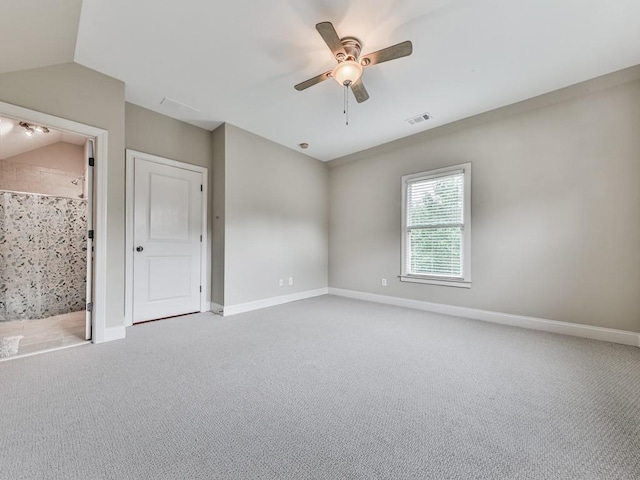 spare room featuring light carpet, ceiling fan, baseboards, and lofted ceiling