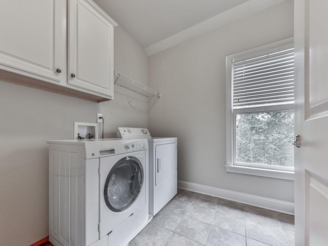 laundry area featuring washing machine and clothes dryer, baseboards, cabinet space, and light tile patterned floors