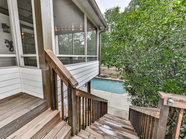 wooden deck featuring an outdoor pool and a sunroom