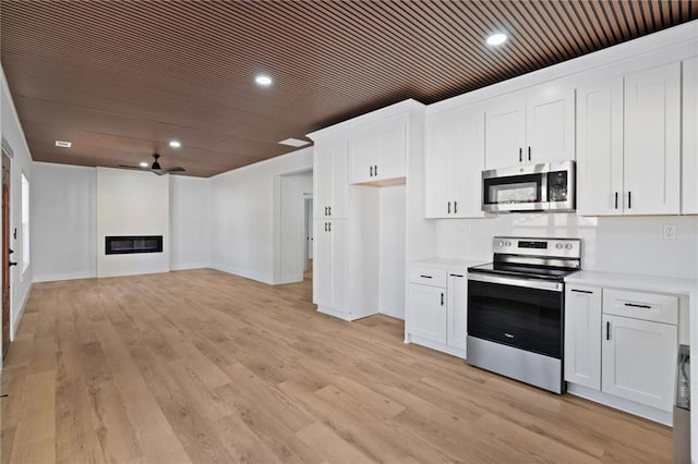 1337 Fairfield Dr, Lilburn, GA 30047 - kitchen featuring stainless steel appliances, light countertops, white cabinets, light wood-type flooring, and recessed lighting