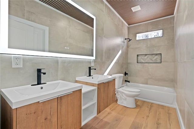 1337 Fairfield Dr, Lilburn, GA 30047 - full bathroom with tile walls, vanity, bathing tub / shower combination, and wood finished floors