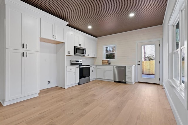 1337 Fairfield Dr, Lilburn, GA 30047 - kitchen featuring stainless steel appliances, light countertops, white cabinetry, light wood finished floors, and recessed lighting