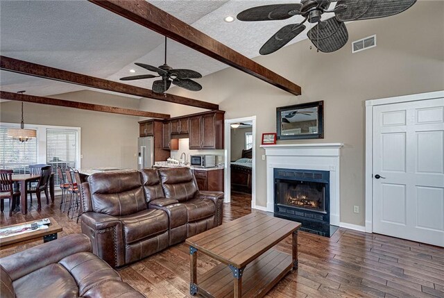 207A Quail Trl, Jackson, GA 30233 - living area with ceiling fan, a textured ceiling, dark wood finished floors, a fireplace with flush hearth, and baseboards