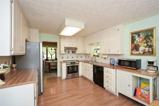 2261 Ravenwood Trl, Marietta, GA 30066 - kitchen featuring stainless steel appliances, plenty of natural light, light wood-type flooring, a sink, and a textured ceiling
