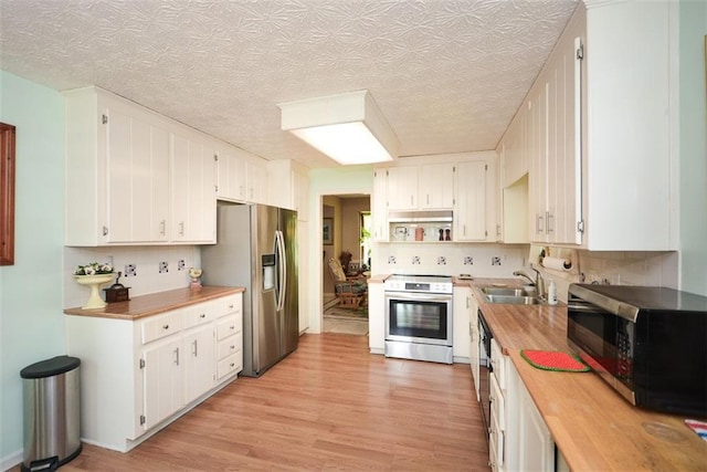 2261 Ravenwood Trl, Marietta, GA 30066 - kitchen with appliances with stainless steel finishes, a sink, wood counters, light wood-type flooring, and a textured ceiling