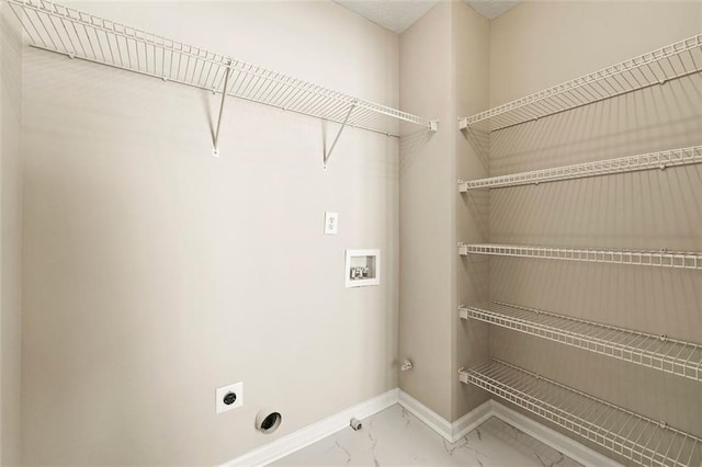 laundry area featuring hookup for a washing machine, laundry area, baseboards, marble finish floor, and electric dryer hookup