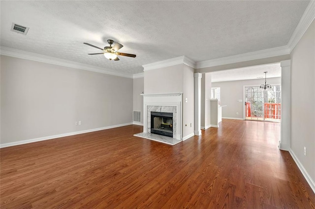 unfurnished living room featuring ceiling fan with notable chandelier, a fireplace, dark wood finished floors, and visible vents