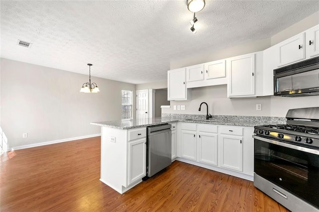 kitchen featuring visible vents, appliances with stainless steel finishes, dark wood-style flooring, a peninsula, and white cabinetry