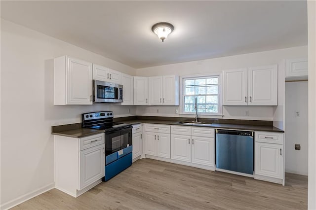 kitchen with white cabinets, light hardwood / wood-style floors, sink, and appliances with stainless steel finishes