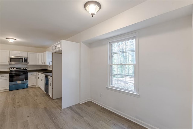 kitchen with white cabinets, stainless steel appliances, and light hardwood / wood-style floors