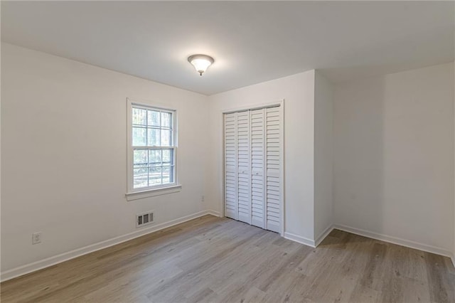 unfurnished bedroom featuring light hardwood / wood-style floors and a closet