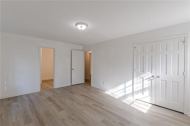 unfurnished bedroom featuring a closet and light hardwood / wood-style floors