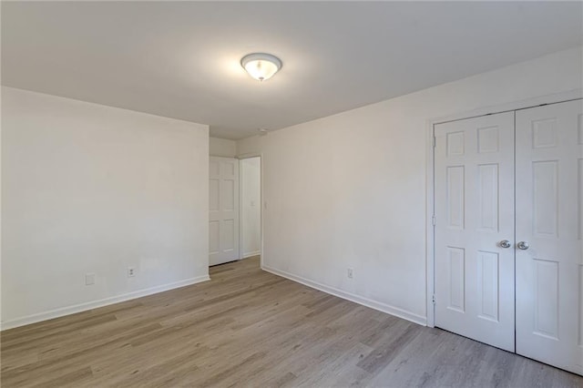 unfurnished bedroom featuring a closet and light hardwood / wood-style floors