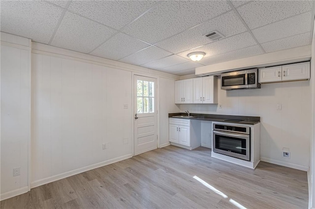 kitchen with white cabinets, light hardwood / wood-style floors, sink, and stainless steel appliances