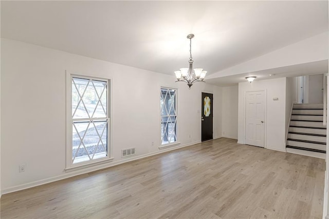 interior space with a chandelier, light hardwood / wood-style floors, and lofted ceiling