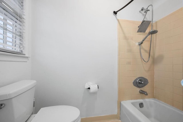 bathroom with toilet and tiled shower / bath combo