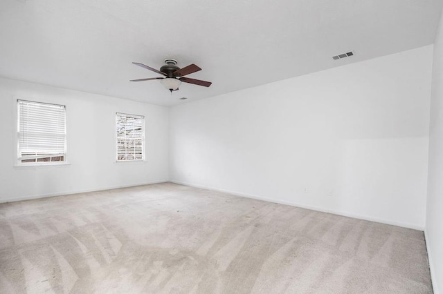 spare room featuring light colored carpet and ceiling fan