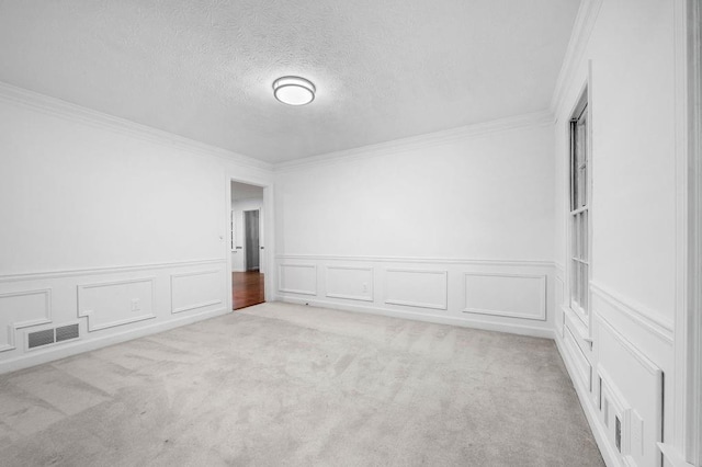 unfurnished room with ornamental molding, light carpet, and a textured ceiling