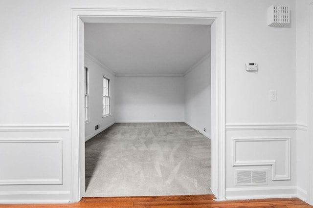 empty room with crown molding and carpet floors