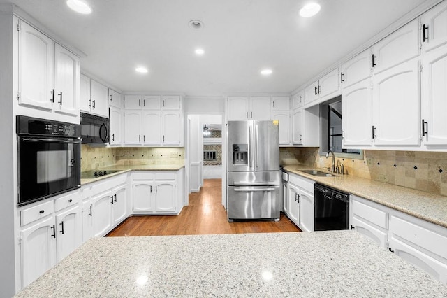 kitchen featuring white cabinetry, sink, and black appliances