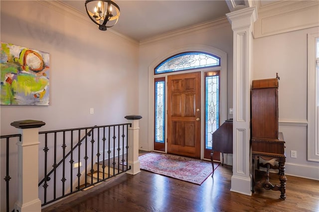 foyer entrance with ornate columns, baseboards, wood finished floors, and crown molding