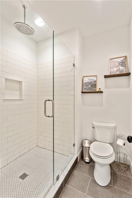 bathroom with toilet, tile patterned flooring, and an enclosed shower