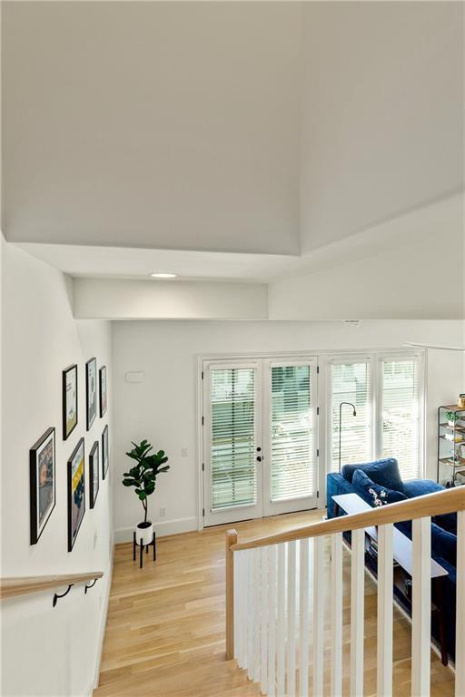 staircase with hardwood / wood-style flooring, french doors, and a high ceiling