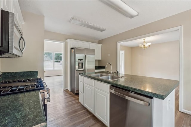 4958 Alpine Ct, Winston, GA 30187 - kitchen with appliances with stainless steel finishes, a sink, dark countertops, wood finished floors, and white cabinetry
