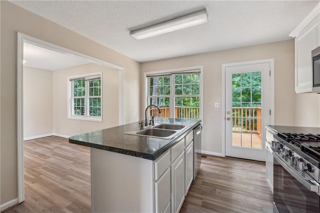 4958 Alpine Ct, Winston, GA 30187 - kitchen featuring a sink, stainless steel appliances, wood finished floors, a textured ceiling, and dark countertops