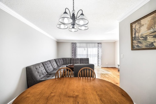 dining room with ornamental molding, a textured ceiling, wood finished floors, a chandelier, and baseboards