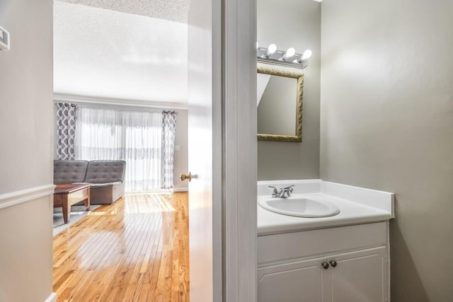 bathroom featuring wood finished floors, a textured ceiling, and vanity